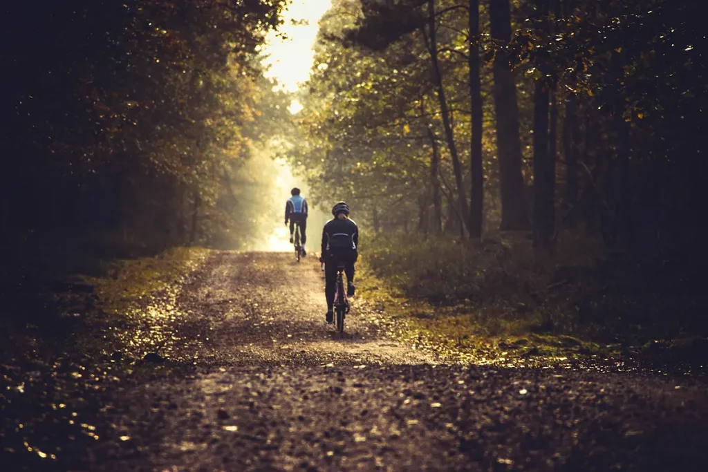 Cycliste sur un chemin forestier ombragé, piste cyclable du Mullerthal