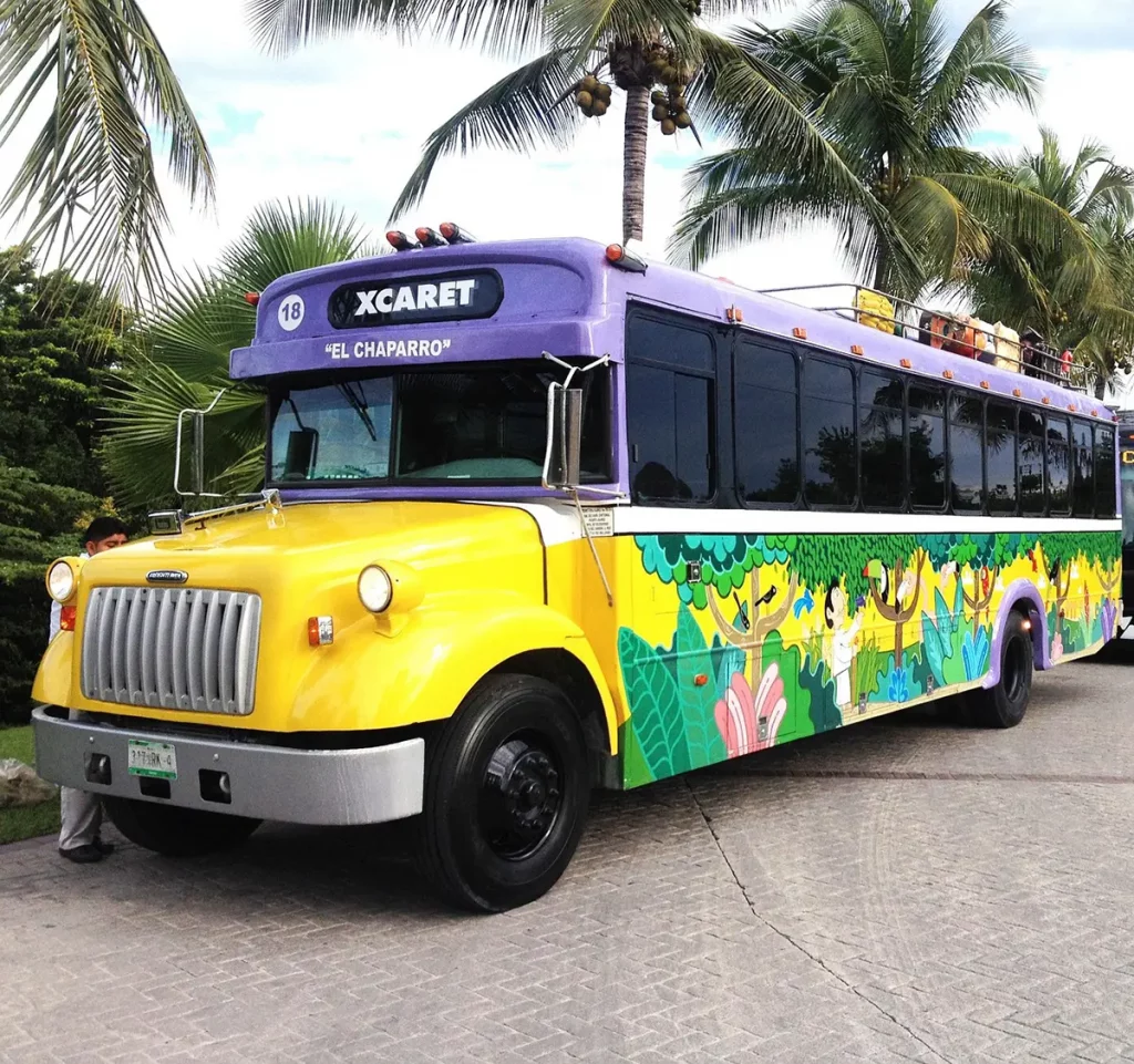 Bus de navette touristique Cancún–Xcaret stationné devant un centre de transport