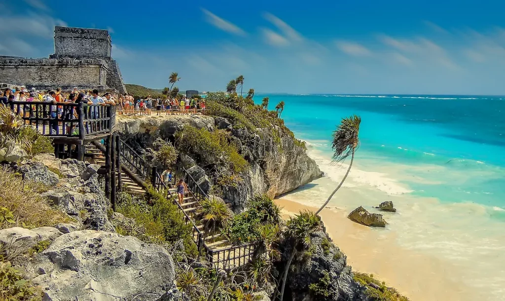 Touristes visitant les ruines mayas de Tulum, perchées sur une falaise surplombant la mer turquoise