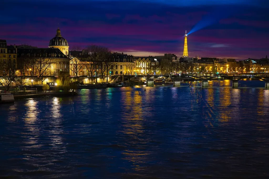 Vue nocturne animée de Paris avec la Seine et les monuments emblématiques en arrière-plan