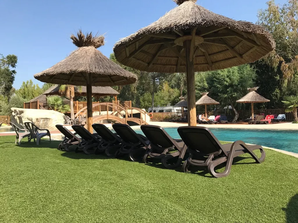 Espace détente avec chaises autour d’une piscine dans un camping à Porto-Vecchio