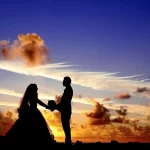 Couple de jeunes mariés au coucher du soleil pendant leur voyage de noces